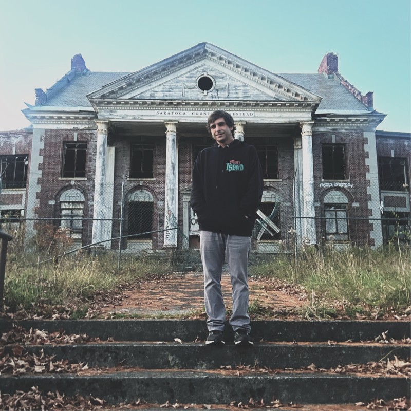 Michael Guerra standing in front of an abandoned building