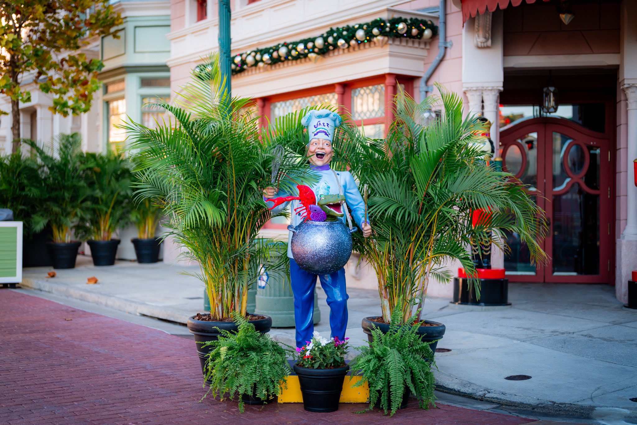 Universal Mardi Gras 2024 chef statue with palm plants